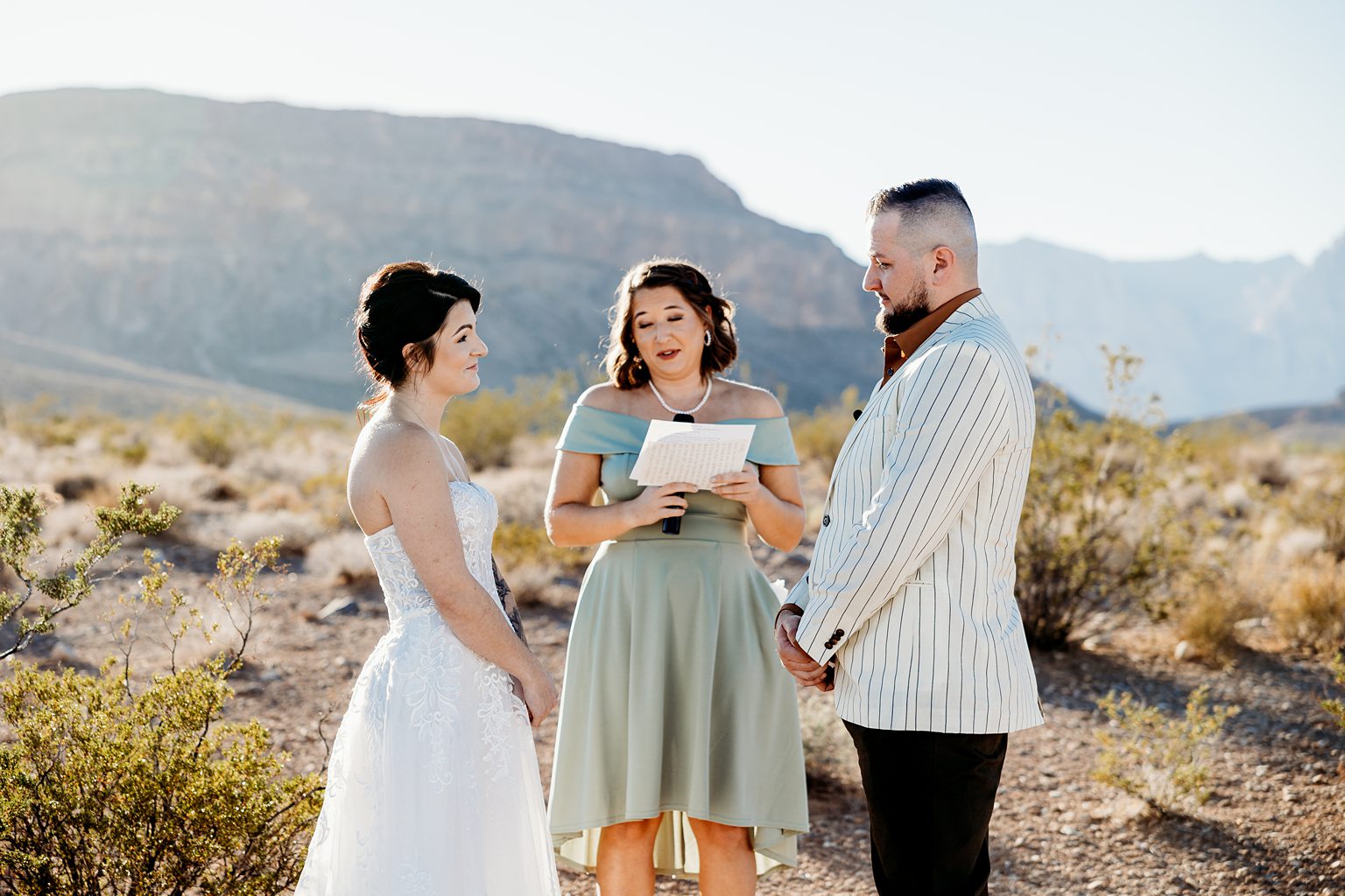 Bride and groom during their outdoor wedding ceremony at Cactus Joe's for their Desert Love Land wedding ceremony