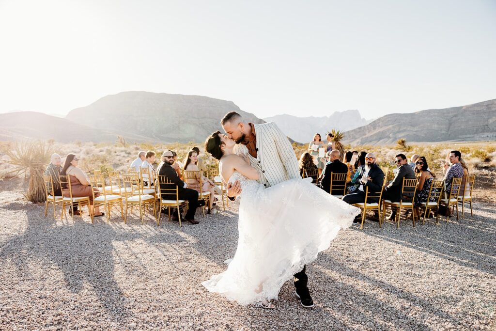 Bride and groom kissing at the end of the aisle during their Cactus Joe's wedding ceremony on Desert Love Land