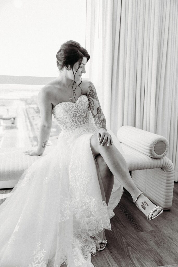 Black and white photo of a bride posing  in her hotel room