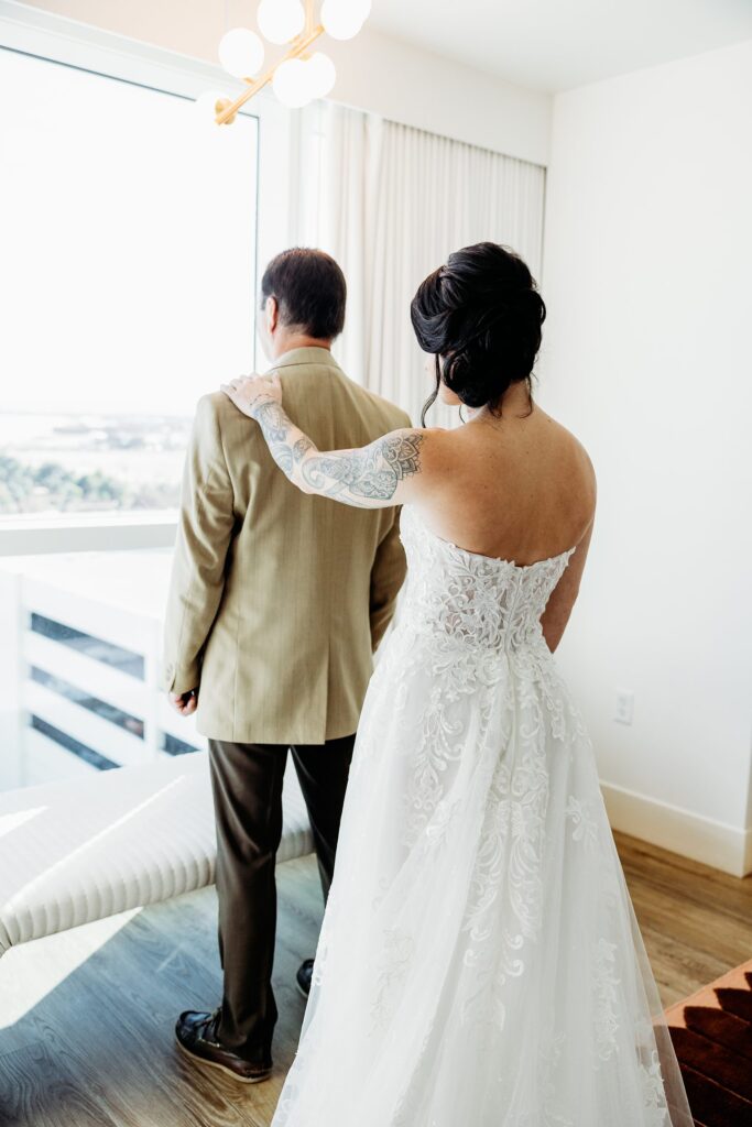 Bride tapping her father on the shoulder for a first look