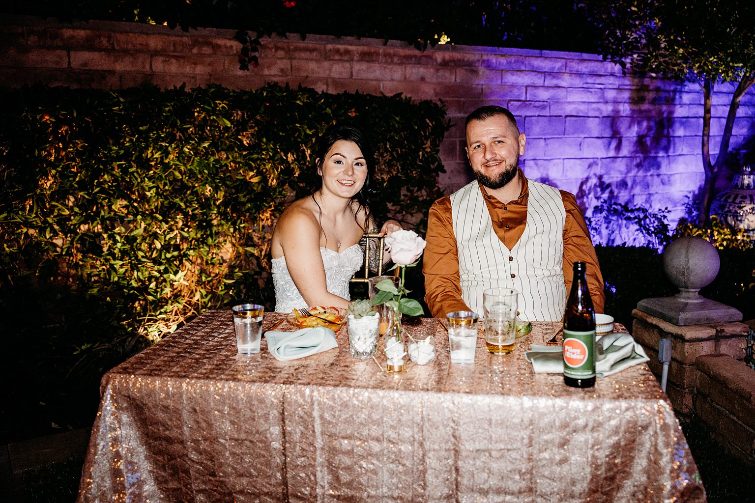 Bride and groom sitting at their sweethearts table