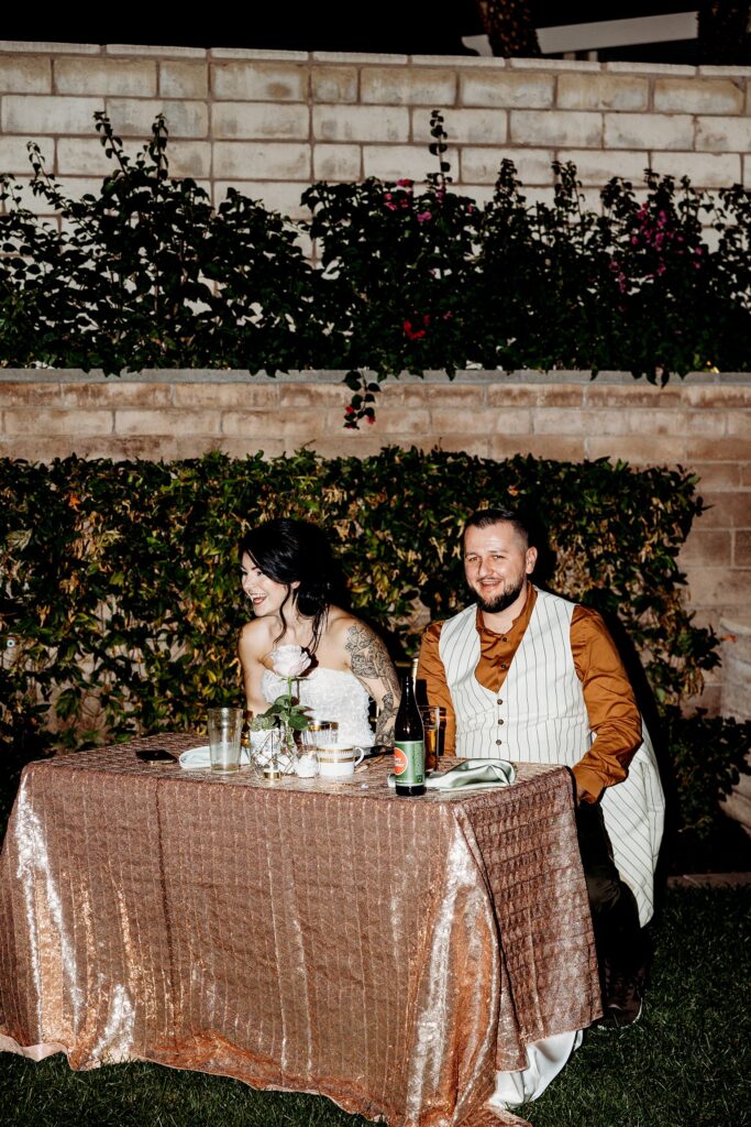 Bride and groom sitting at their sweethearts table