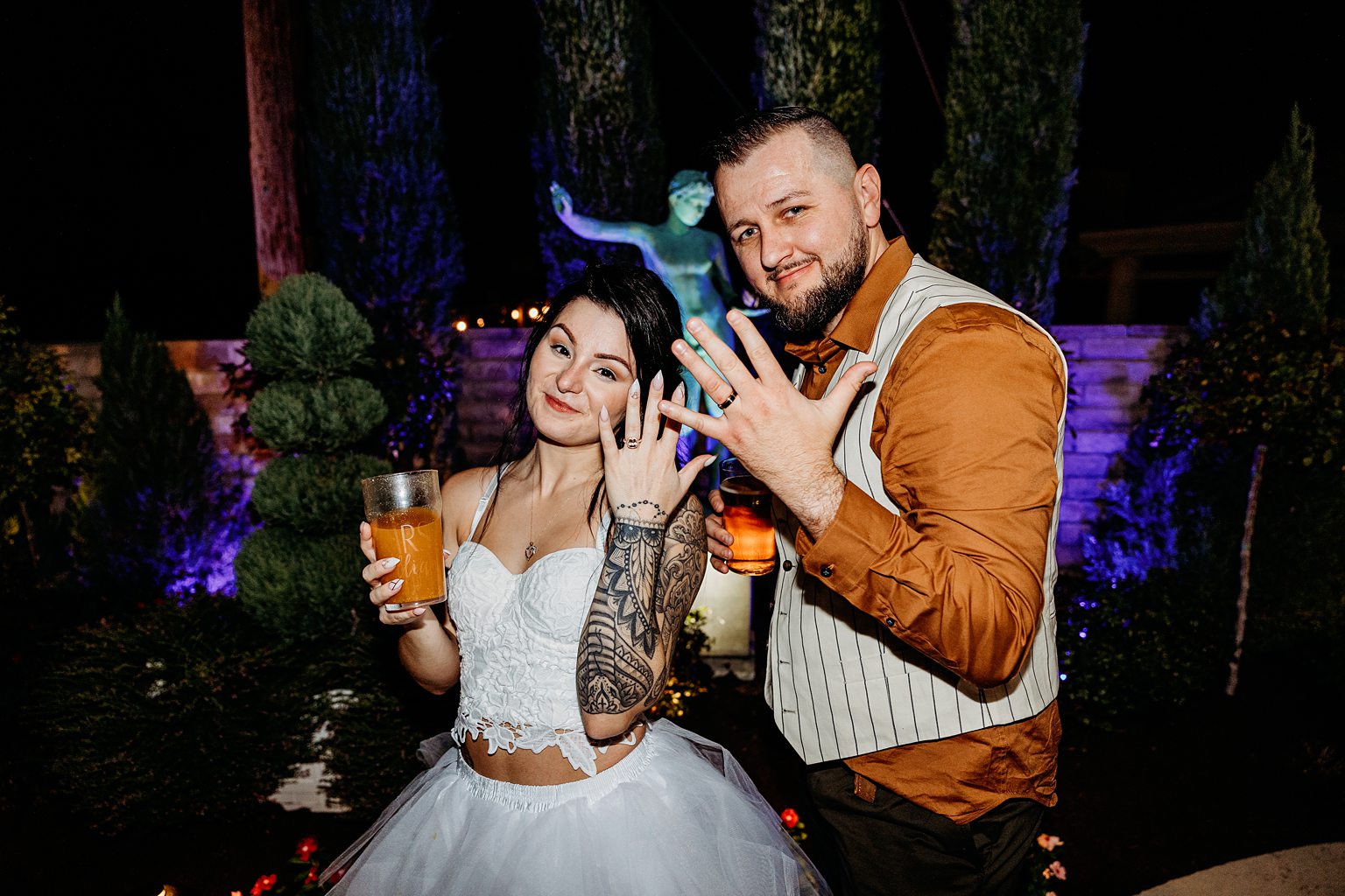 Bride and groom showing off their wedding rings at the end of the night