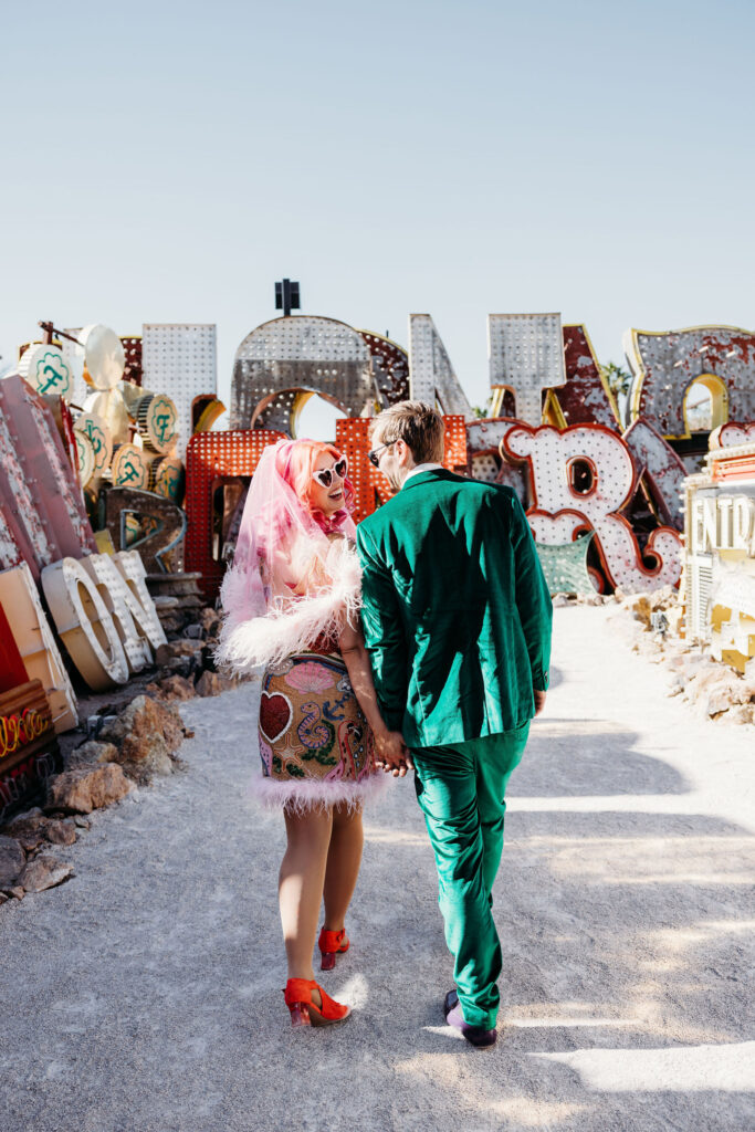 bride and groom walking around the neon museum in las vegas