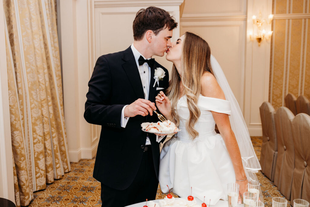Cute picture of the newly married couple kissing after cutting their wedding cake