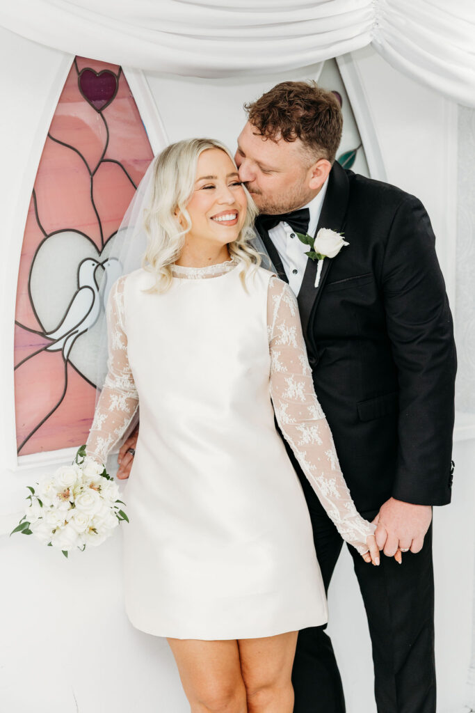 groom kissing the bride on the cheek