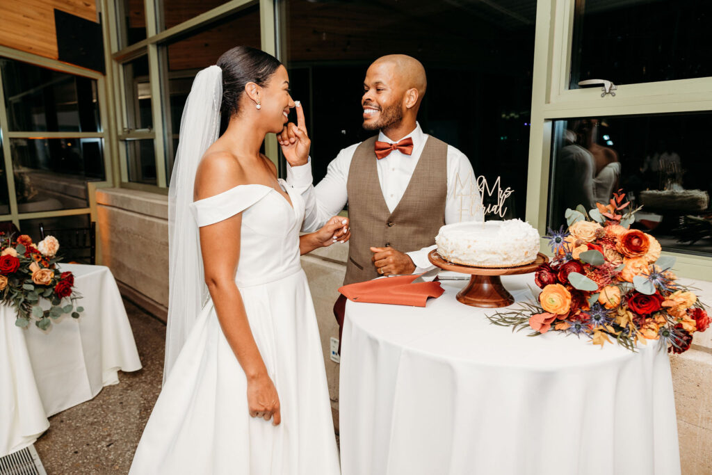 newlyweds trying their wedding cake