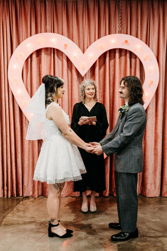 Bride and groom holding hands during their wedding ceremony