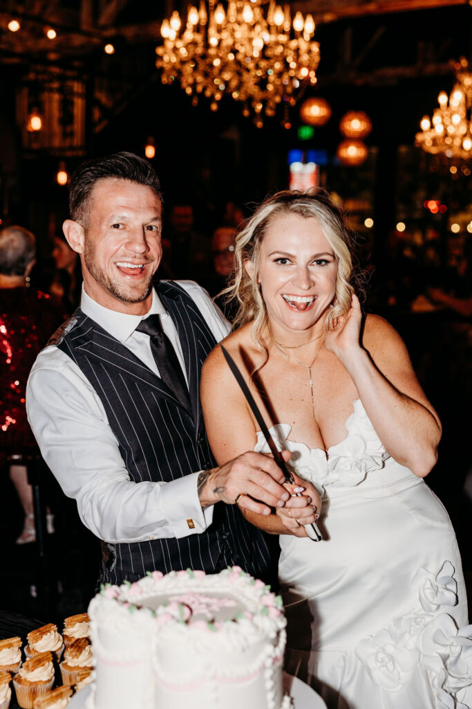 portrait of the newlyweds cutting their wedding cake