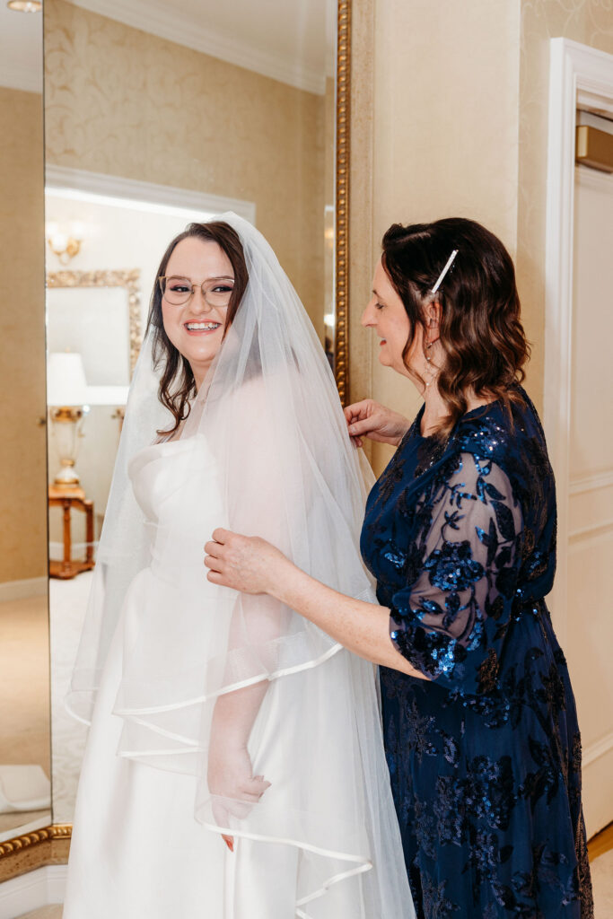 mother of the bride helping her with the wedding dress
