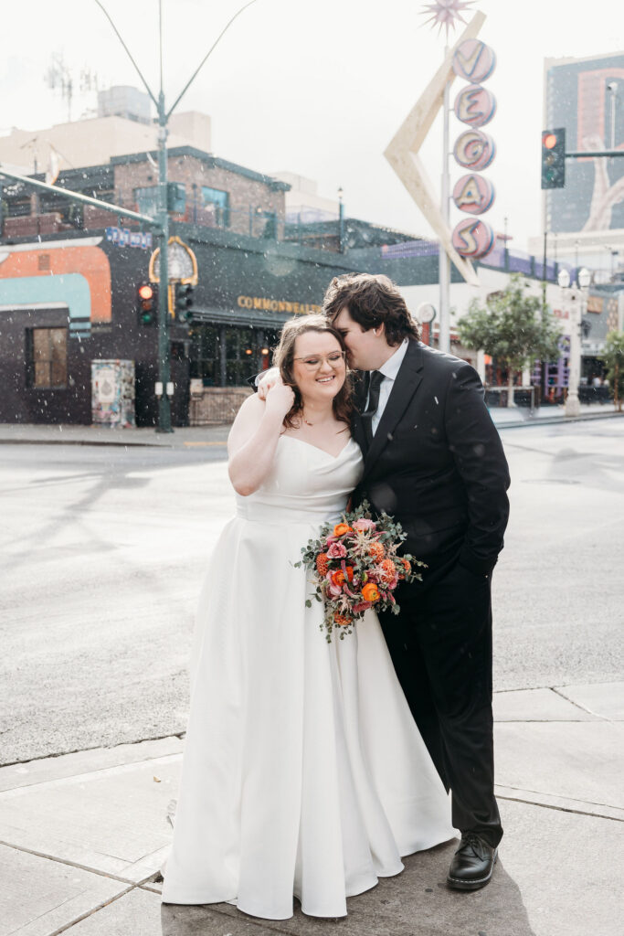 Groom, kissing the bride on the cheek